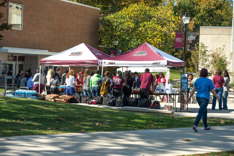 Students gathering around free giveaway tent by student center